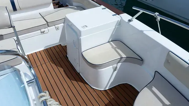 Un barco blanco con una cubierta de madera y un asiento blanco.