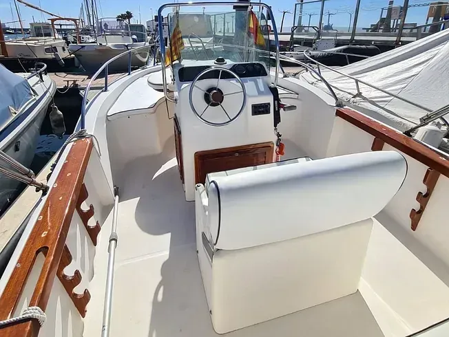 Un barco blanco con un volante y un asiento.
