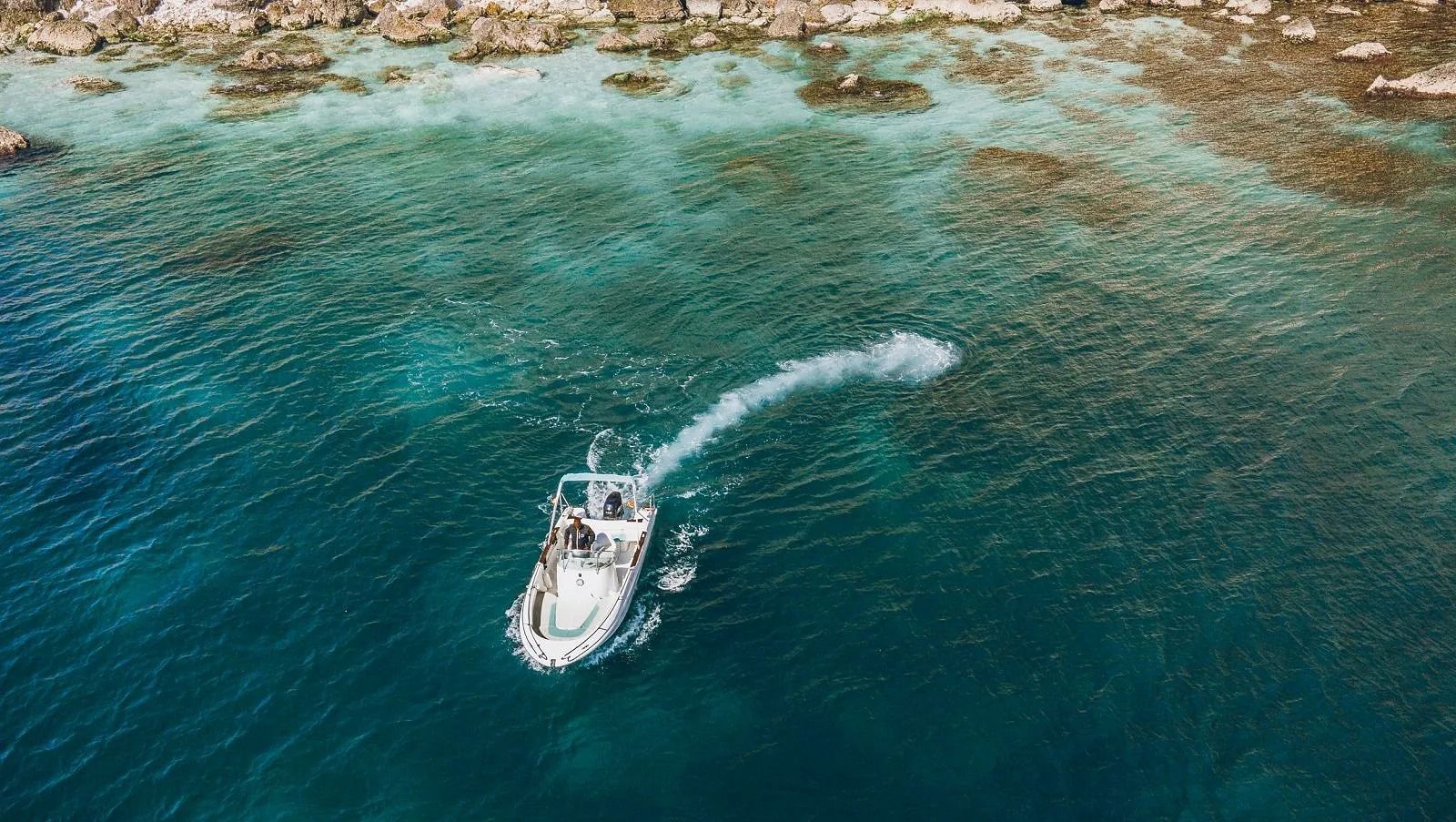 Una vista aérea de un barco flotando sobre un cuerpo de agua.