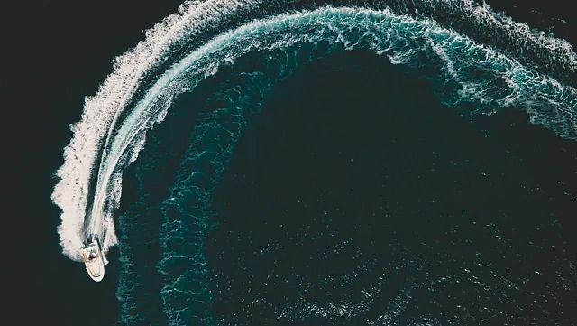 Una vista aérea de un barco surfeando una ola en el océano.