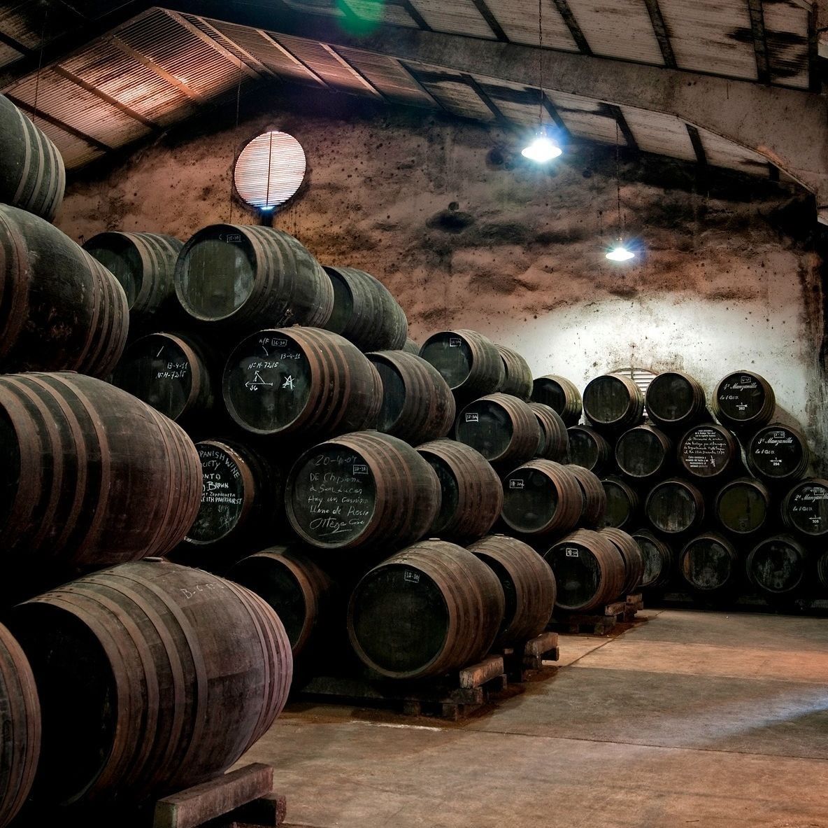 Un almacén lleno de muchos barriles y un reloj en la pared.