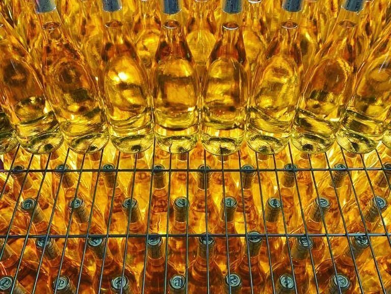 Un montón de botellas de cerveza están en un estante.