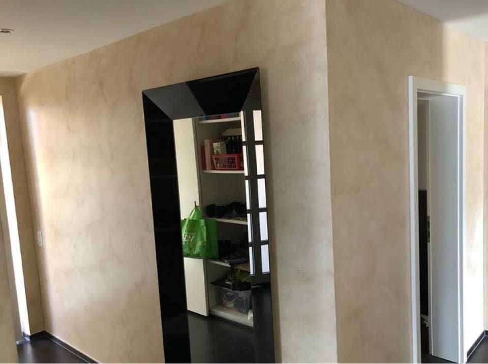 Lapide e muro con rifiniture rosa.