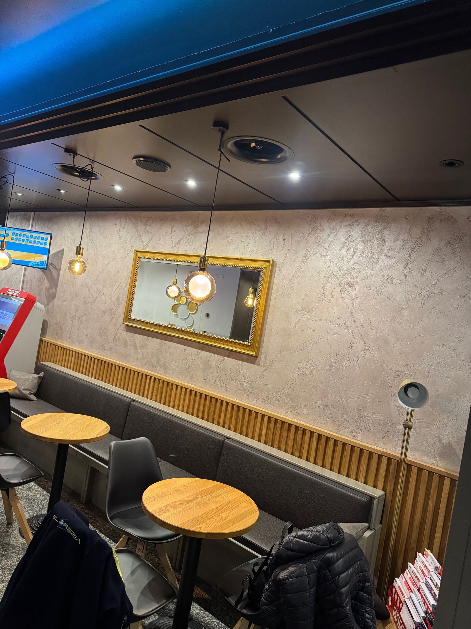 Porta in legno con assi orizzontali, dipinta di marrone, su una parete in stucco bianco.