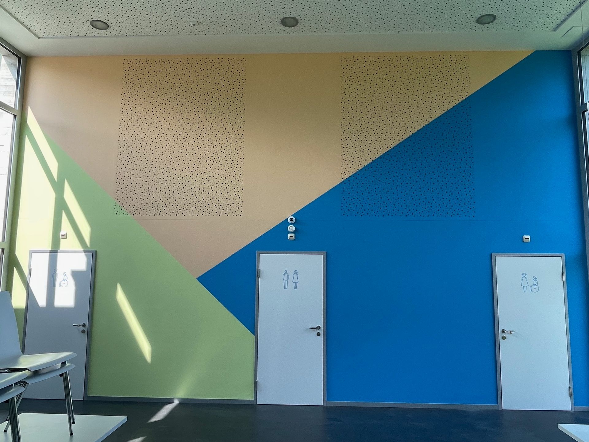 Vista a due pannelli dell'esterno di un edificio. L'immagine in alto è distorta. L'immagine in basso mostra l'edificio con colonne e gradini.