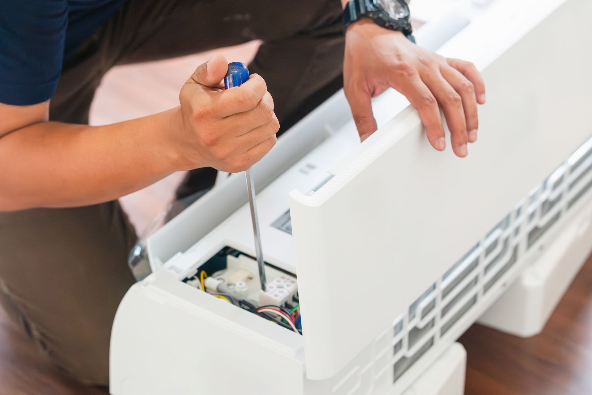 Um homem de macacão com uma caixa de ferramentas cumprimenta uma mulher à porta.