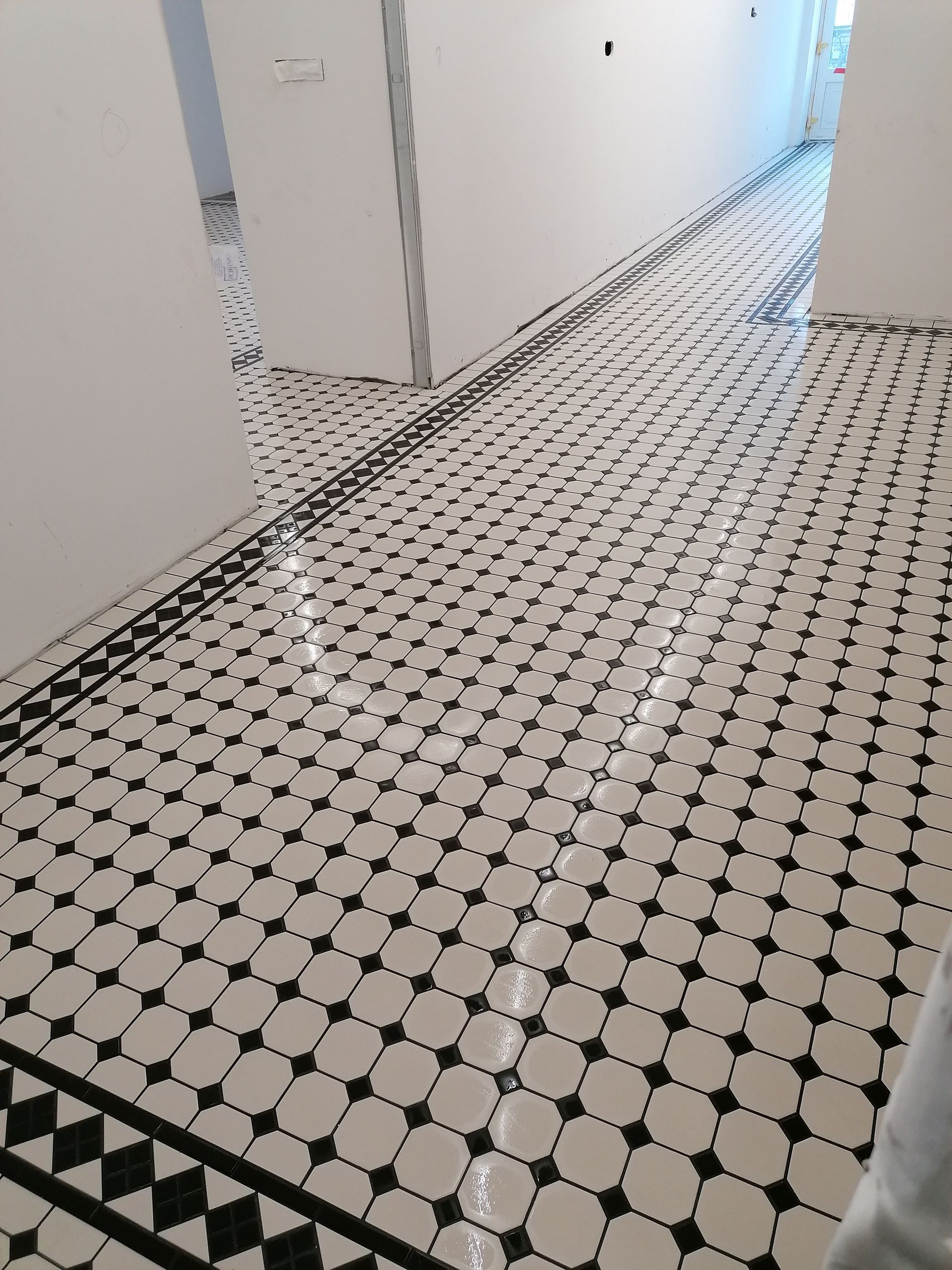 Terrasse en bois avec table et chaises, fleurs au premier plan, bâtiment en bois à l'arrière-plan.