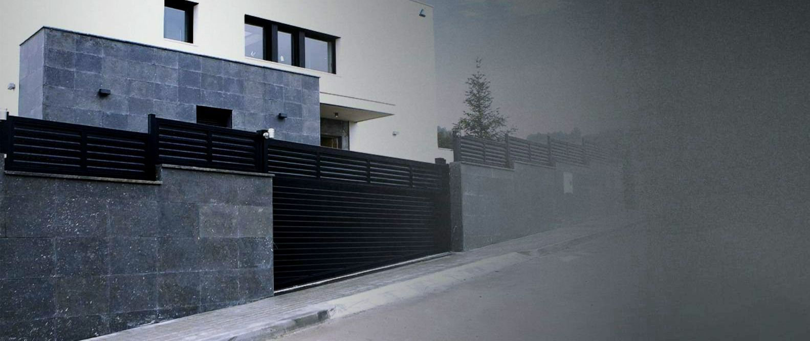 Une façade de maison avec un portail et un muret