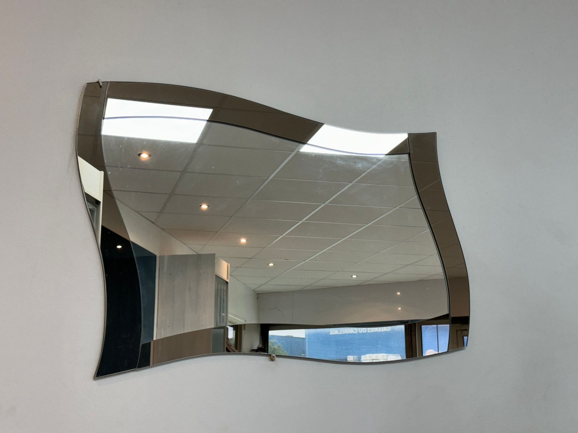 Miroir en forme de vague accroché au mur