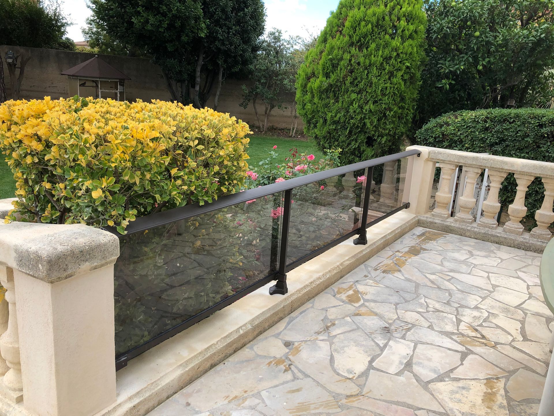 Un balcon avec un garde-corps en verre et un en béton