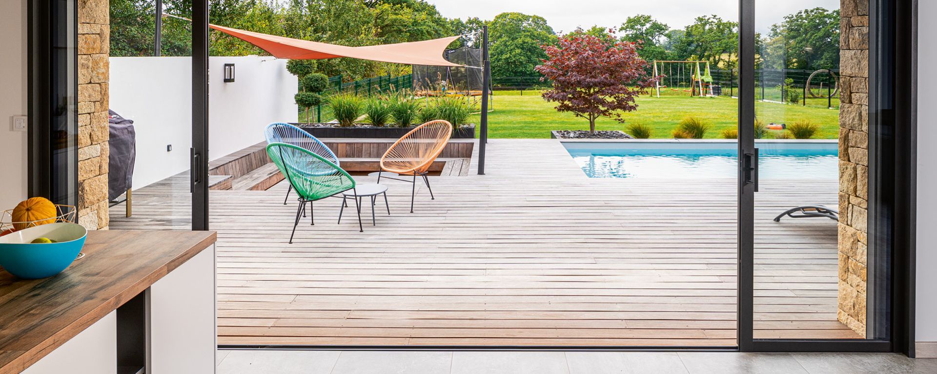 Ouverture d'une baie coulissante menant vers une terrasse et une piscine
