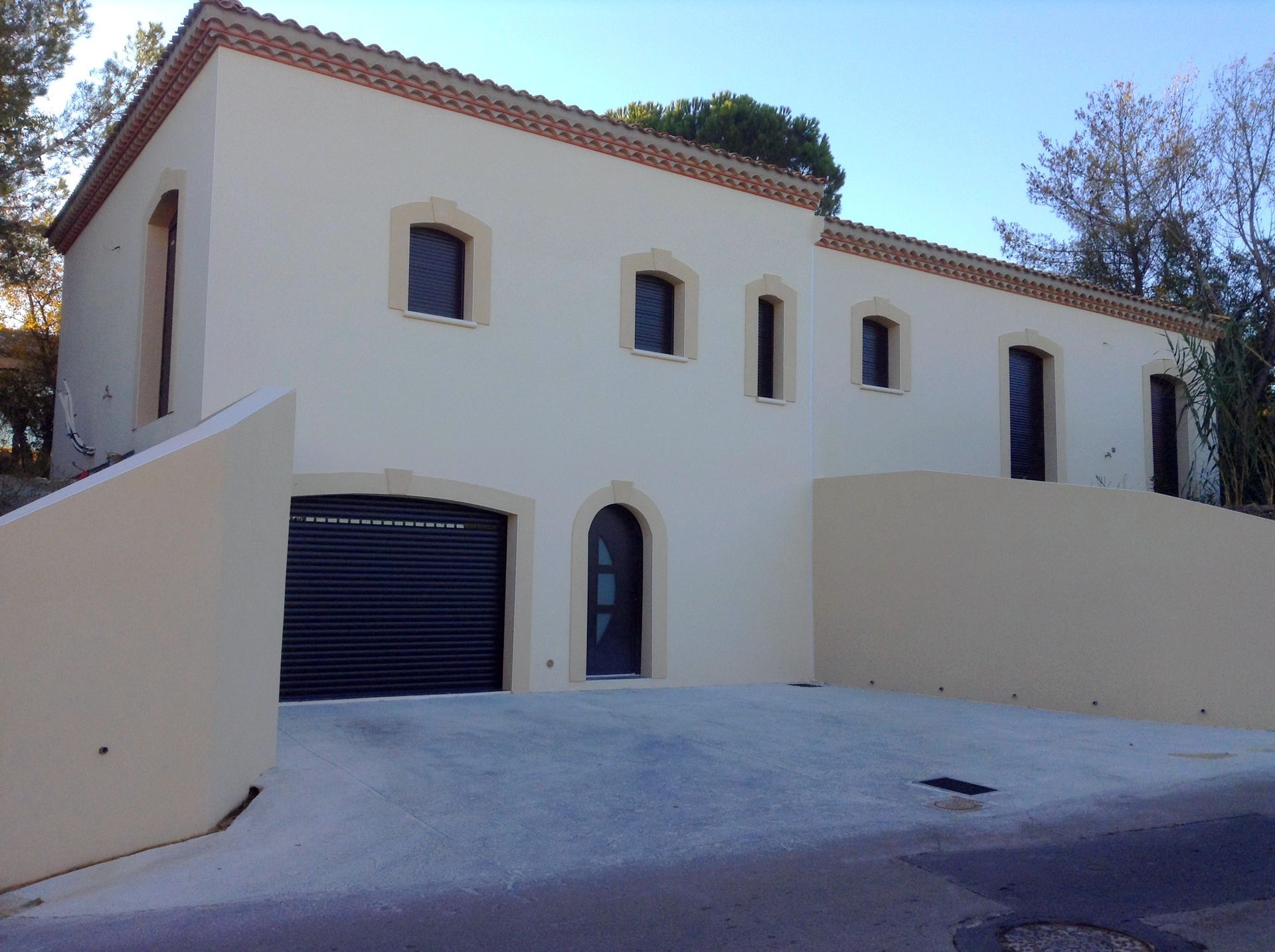 Maison à la façade couleur crème avec porte d'entrée et garage