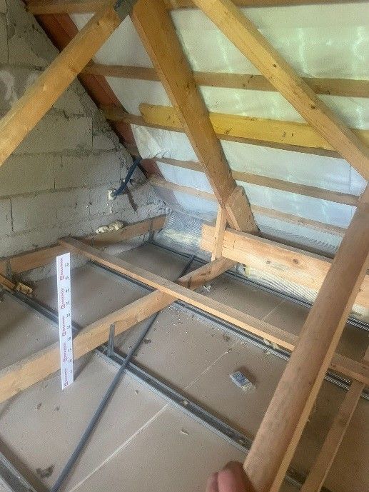 Charpente de grenier en bois avec isolation, vue intérieure.