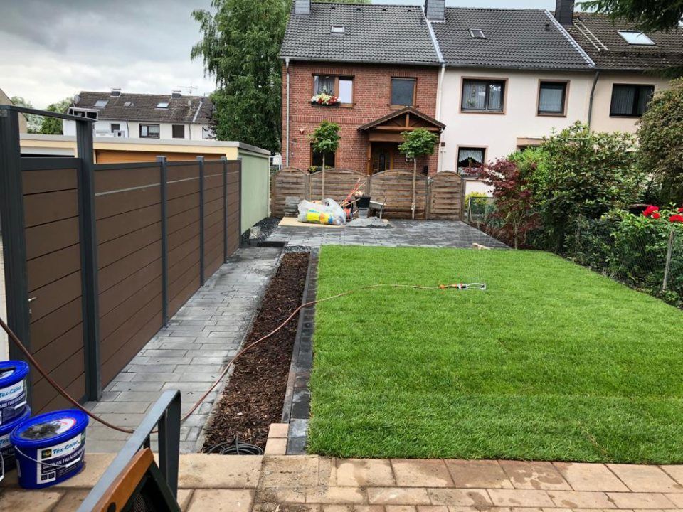 Ein Hinterhof mit Zaun und üppigem grünen Rasen