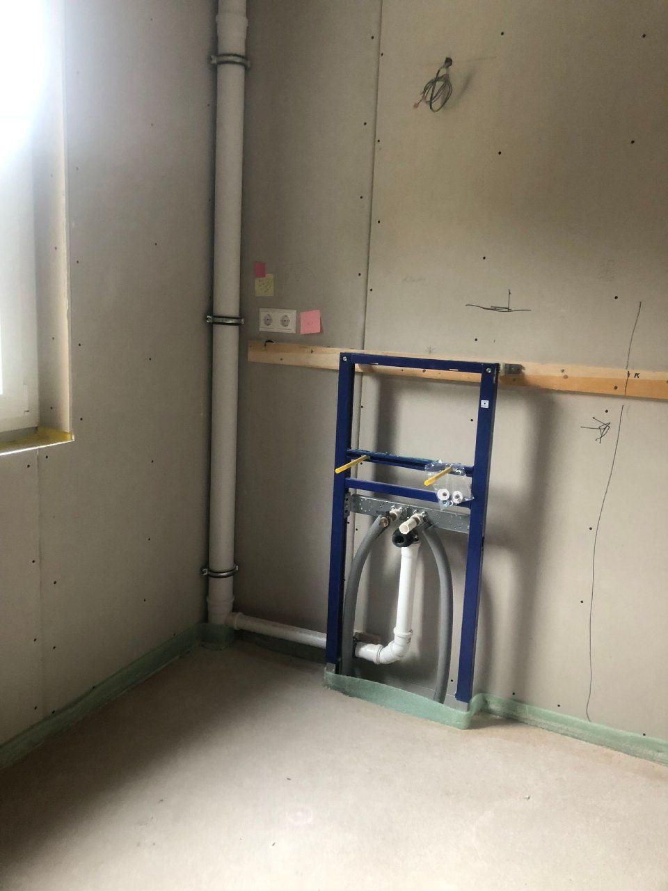Ein im Bau befindliches Badezimmer mit Waschbecken und Rohren