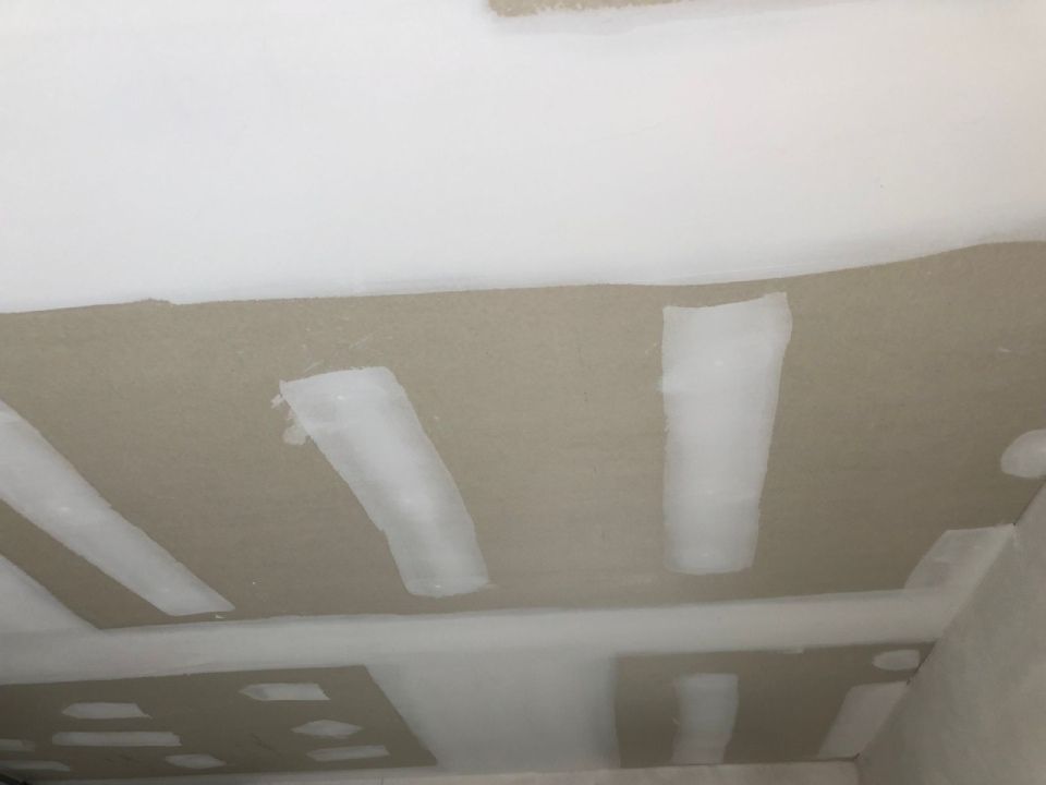 Eine Nahaufnahme einer Trockenbaudecke in einem Raum.