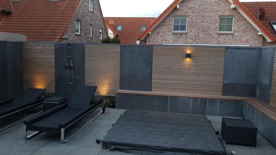 Ein Backsteingebäude mit einem Zaun und Stühlen davor