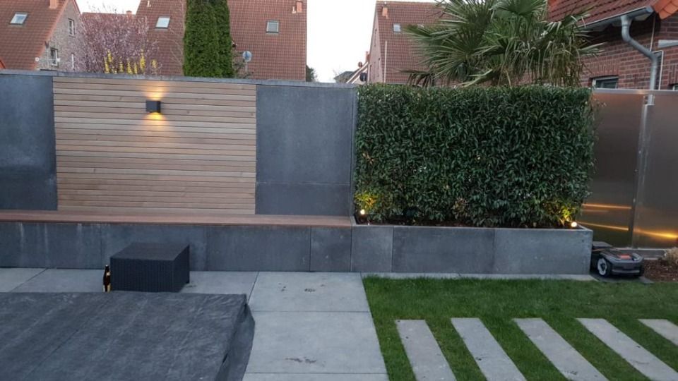 Ein Hinterhof mit einer Holzmauer und einem Edelstahlzaun