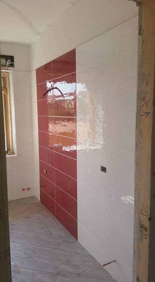 Ein Badezimmer mit roten und weißen Fliesen an den Wänden und auf dem Boden.