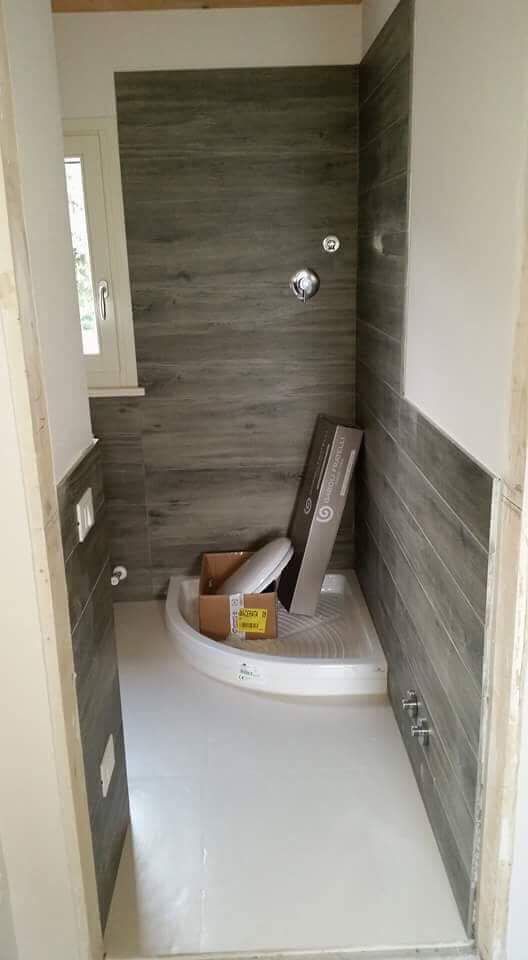 Ein Badezimmer mit Duschkabine und einer Box auf dem Boden.