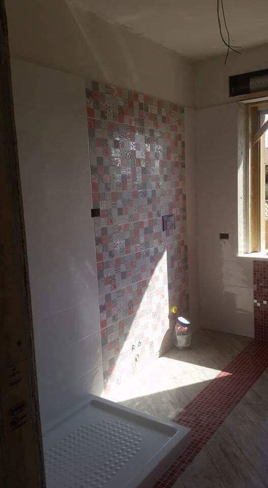 Ein im Bau befindliches Badezimmer mit Duschkabine und Fenster.