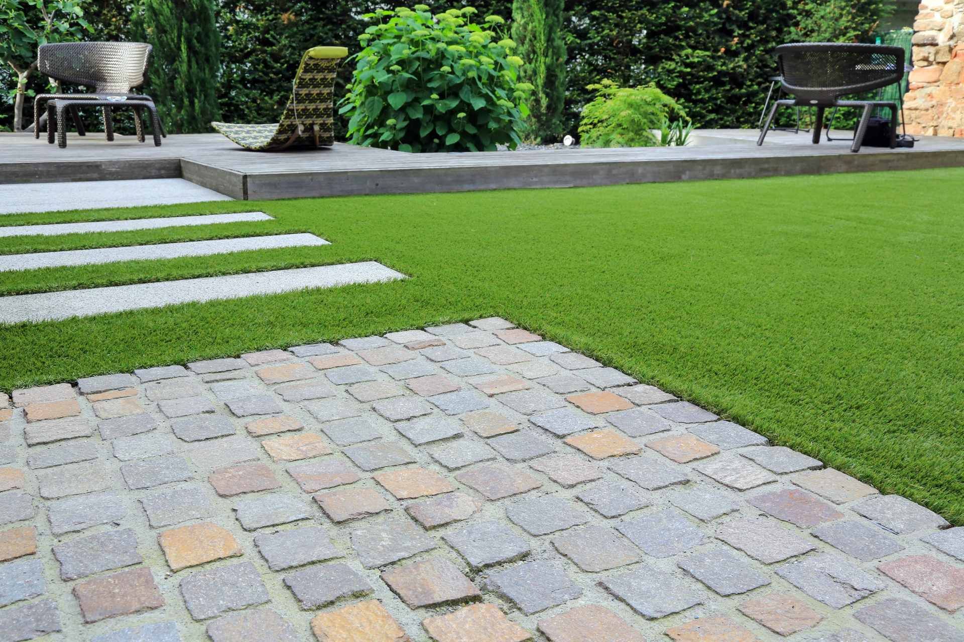 Ein gemauerter Gehweg, der zu einer Terrasse in einem Hinterhof führt