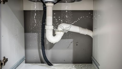 Fuite d'eau provenant de la plomberie sous l'évier, à l'intérieur d'un meuble.