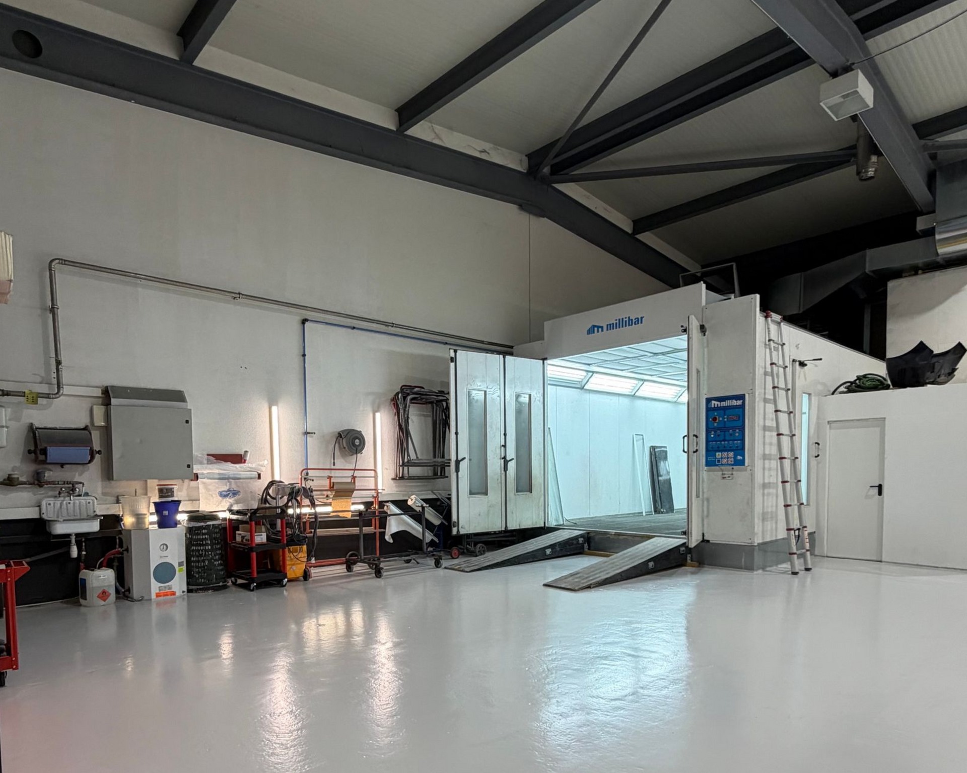 Une cabine de peinture automobile impeccable dans un atelier de réparation spacieux