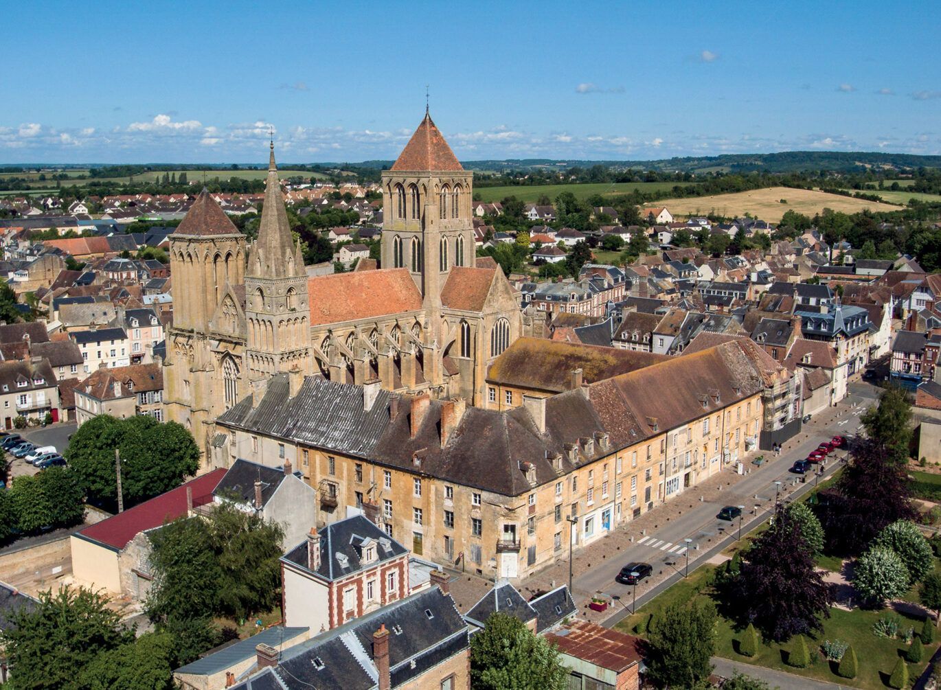 Illustration d'un paysage verdoyant avec un lac, des routes, des maisons, des arbres, un camping et des véhicules.