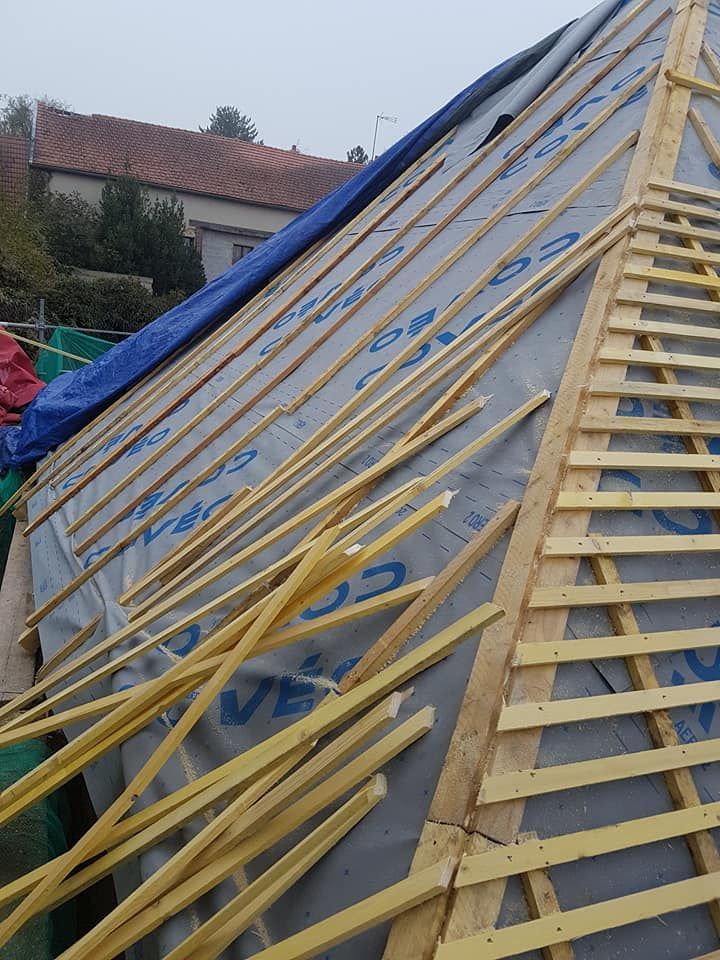 Toiture en construction avec fermes en bois et contreventements jaunes sur une maison