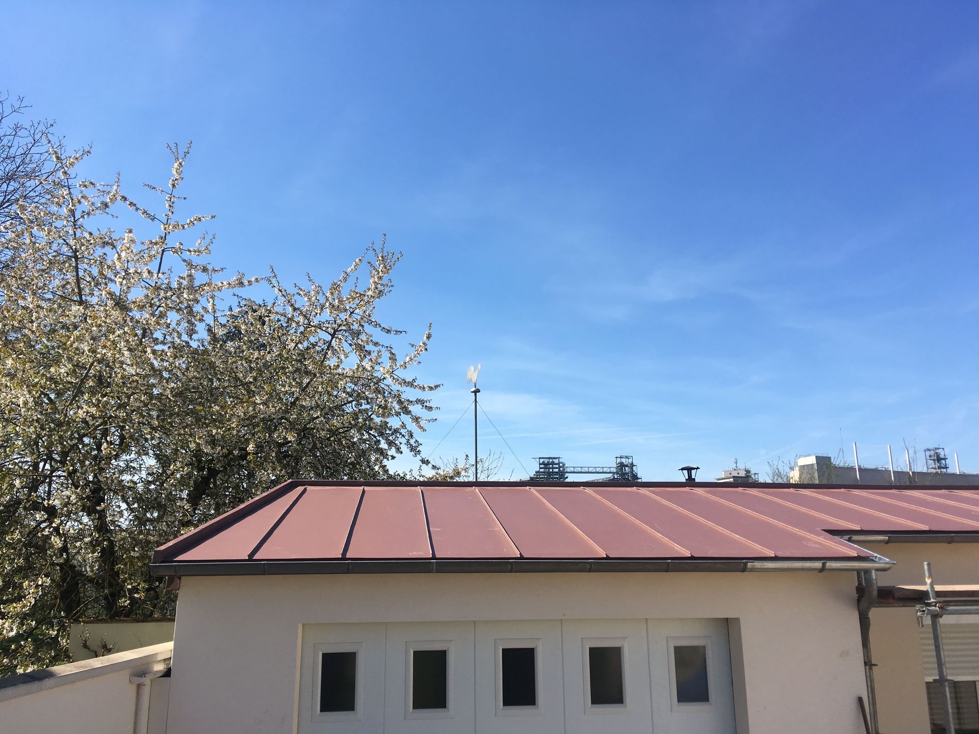Toits de tuiles rouges avec une lucarne sous un ciel bleu clair