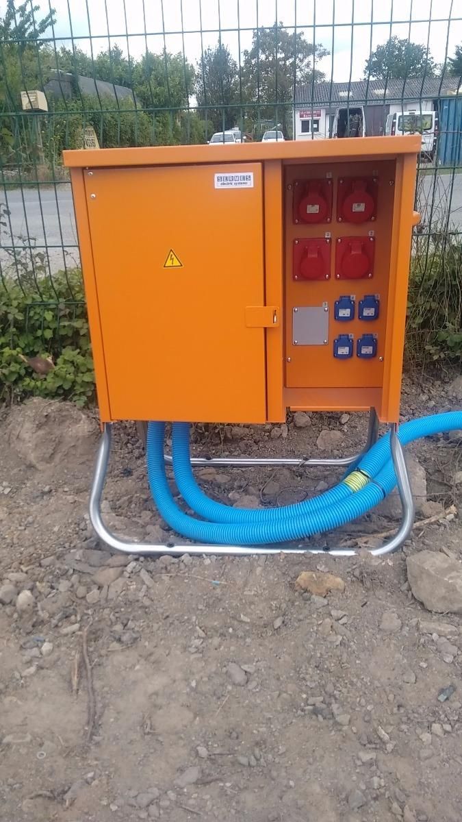 Installation d'une armoire électrique orange à l'extérieur avec des câbles bleus