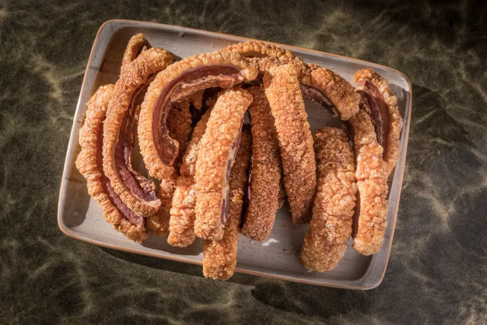 Un plato de costillas de cerdo fritas en una mesa.