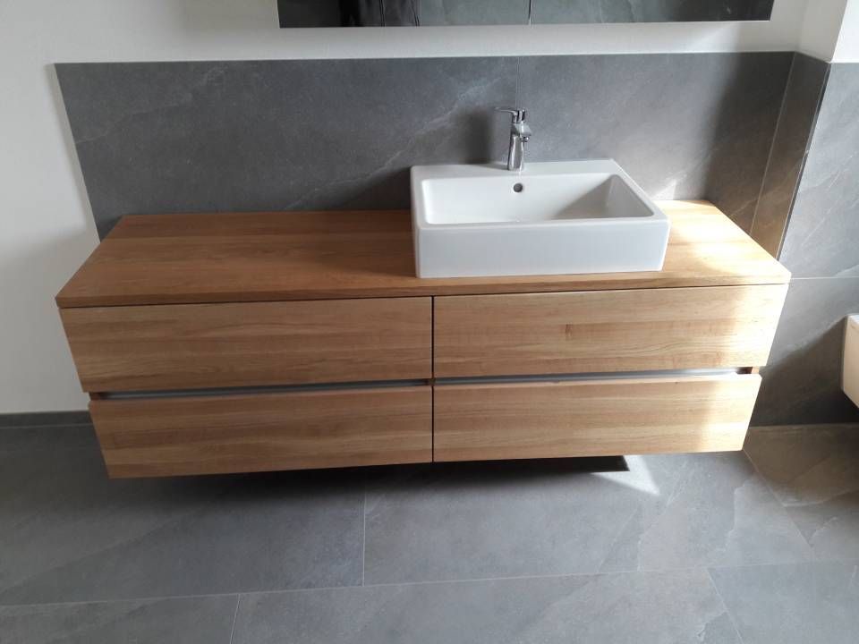 Moderner Waschtisch aus Holz mit weissem Waschbecken und Armatur vor einer grauen Wand