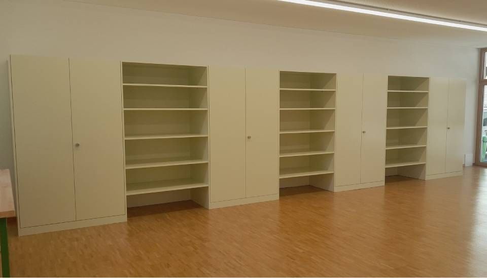 Leeres Zimmer mit eingebauten beigefarbenen Regalen und Schränken auf einem Hartholzboden