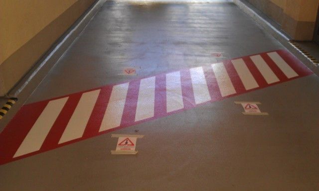 Fahrbahnmarkierung eines Zebrastreifens in einer Garage