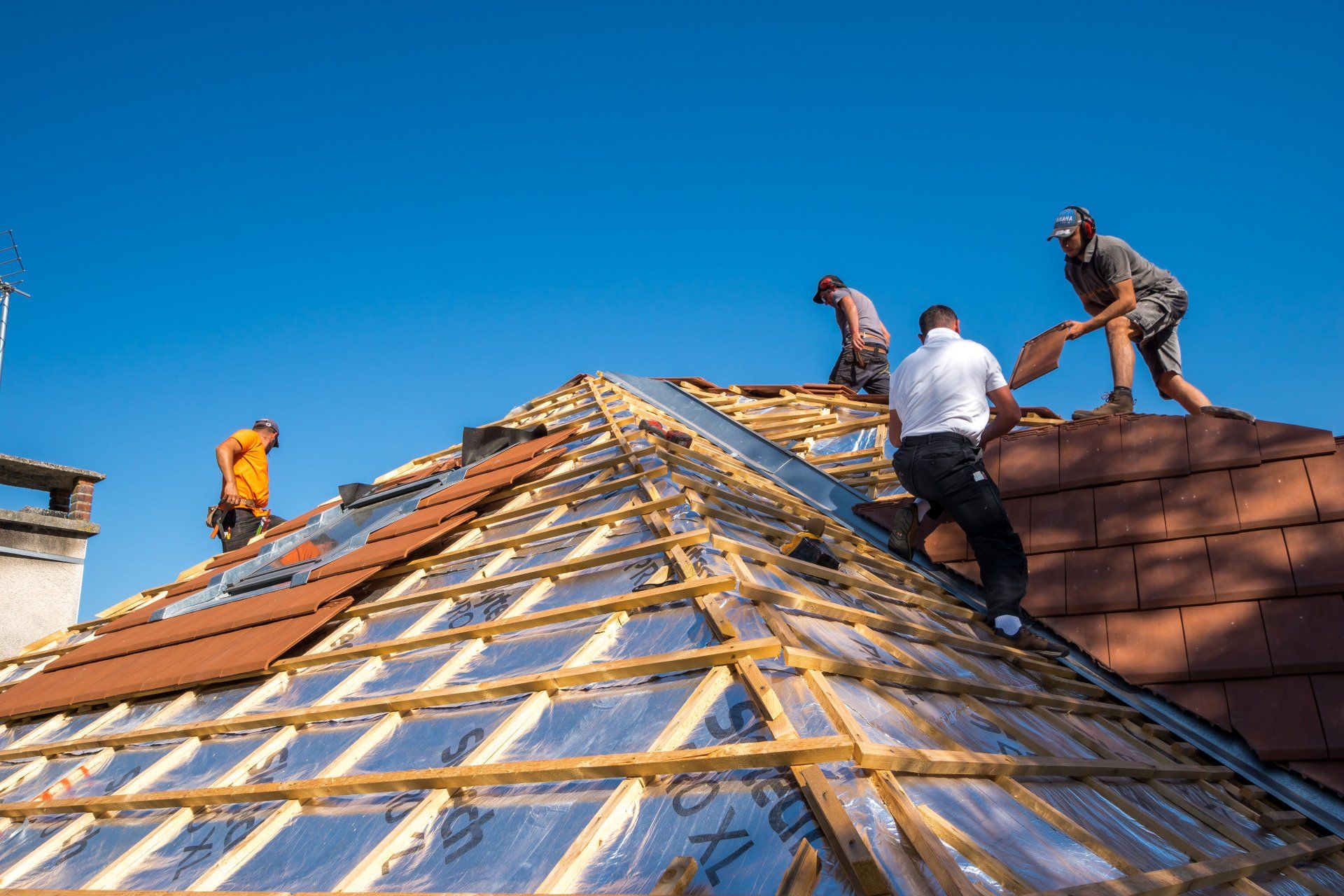 Ouvriers posant des tuiles sur une charpente