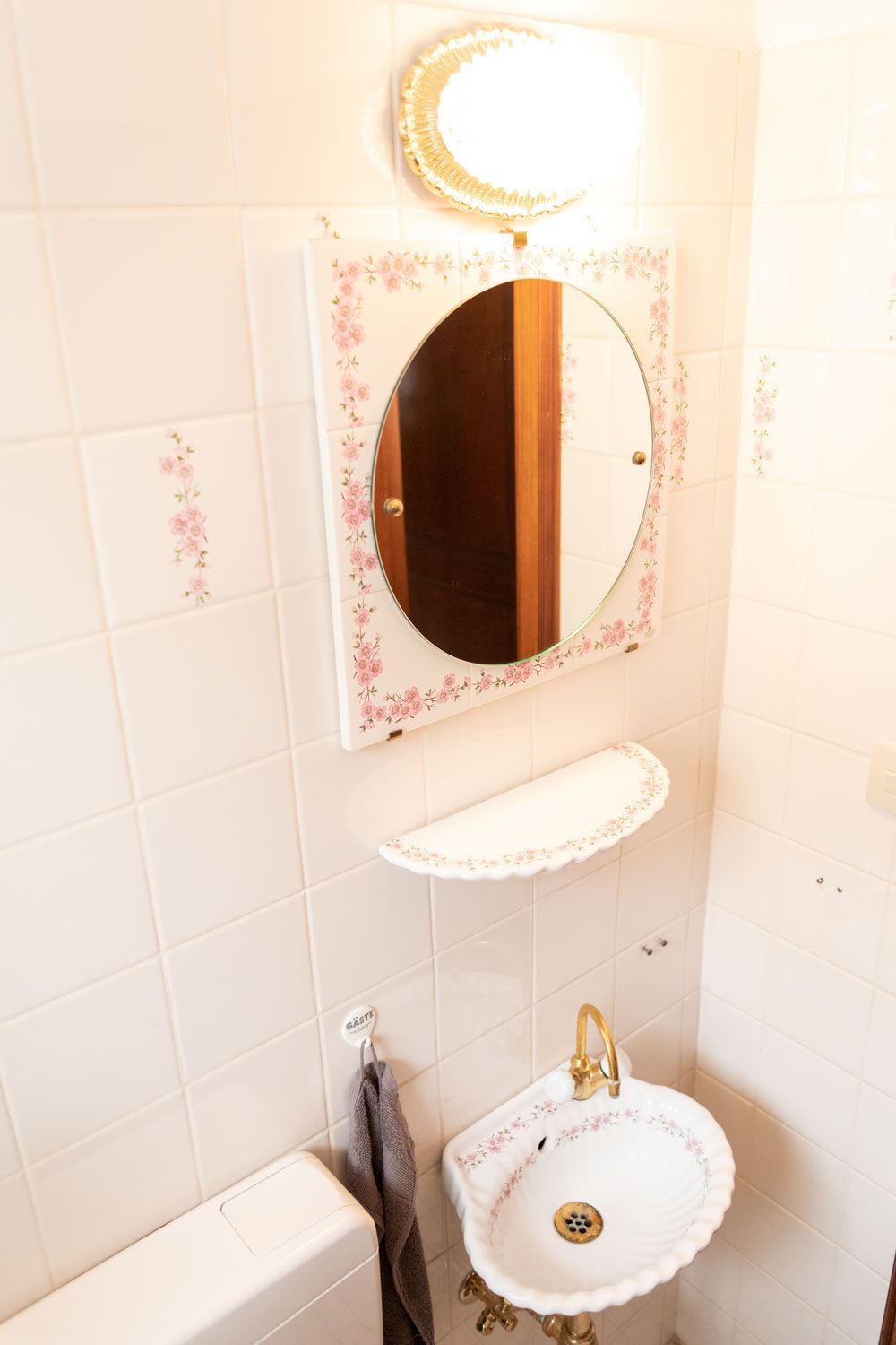 Ein Badezimmer mit Waschbecken, Spiegel und Toilette.