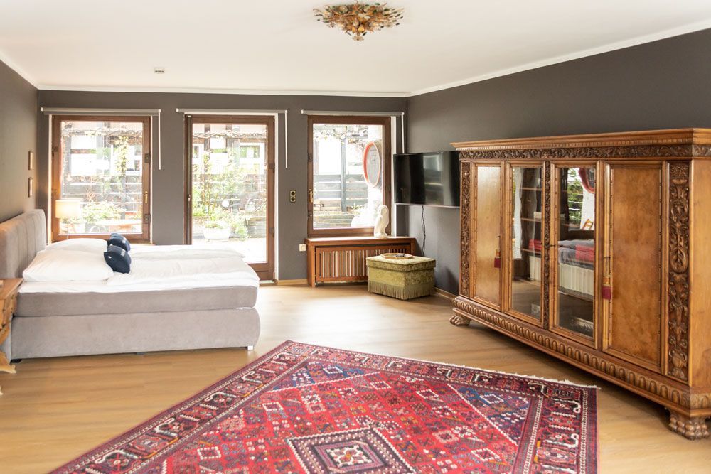 Ein Schlafzimmer mit zwei Betten, einem Teppich, einem Kleiderschrank und einem Fernseher.