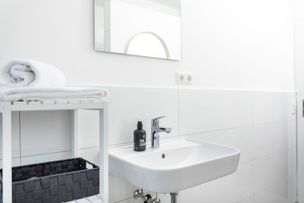 Ein Badezimmer mit Waschbecken, Spiegel und Handtuchhalter.