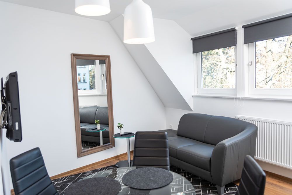 Ein Wohnzimmer mit einer Couch, einem Tisch und einem Spiegel