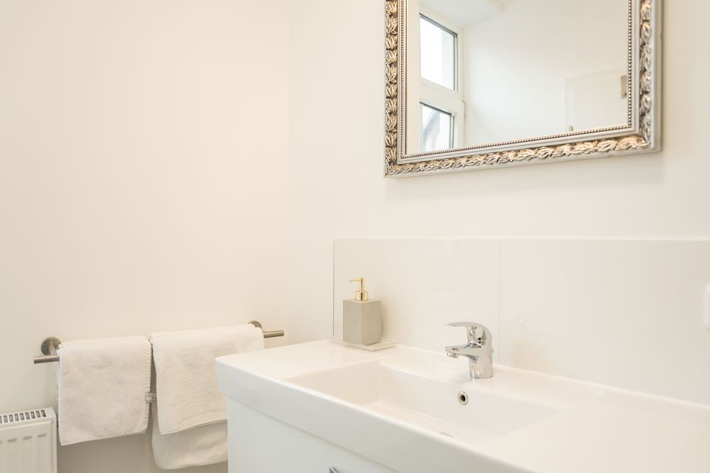 Ein Badezimmer mit Waschbecken, Spiegel und Handtüchern.