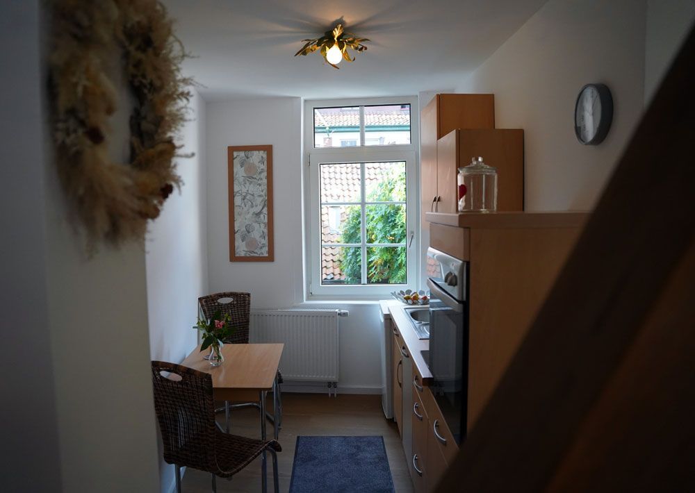 Eine Küche mit Tisch und Stühlen und einer Uhr an der Wand