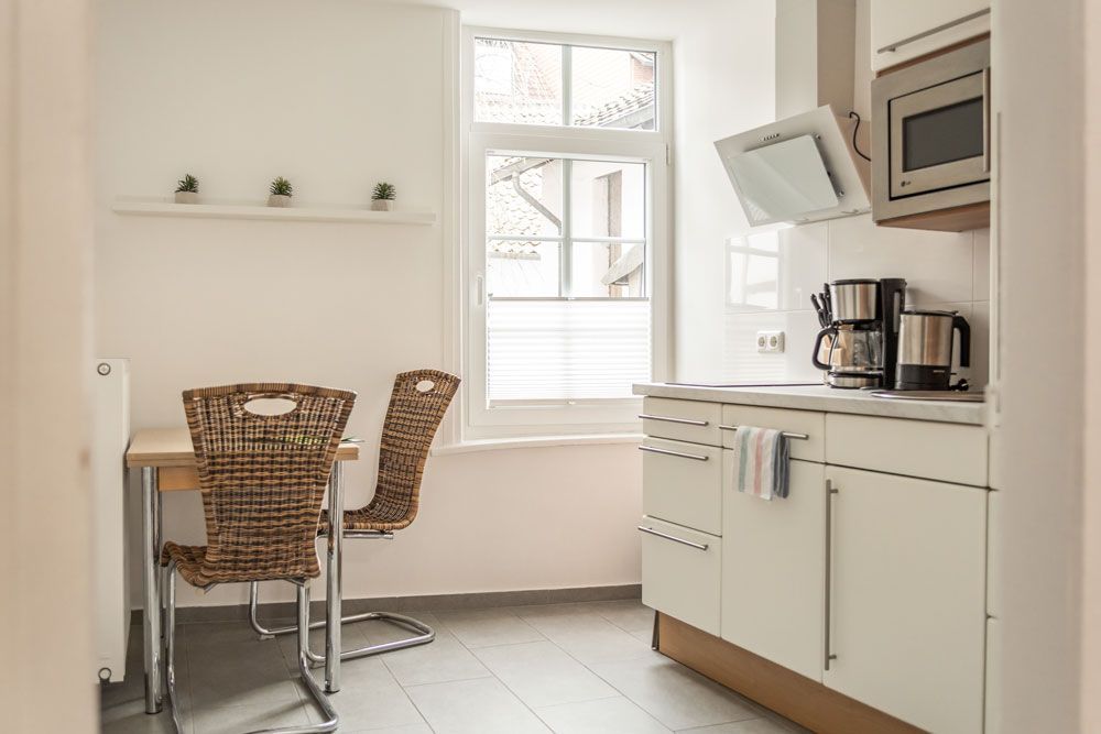 Eine Küche mit Tisch und Stühlen und einer Mikrowelle.