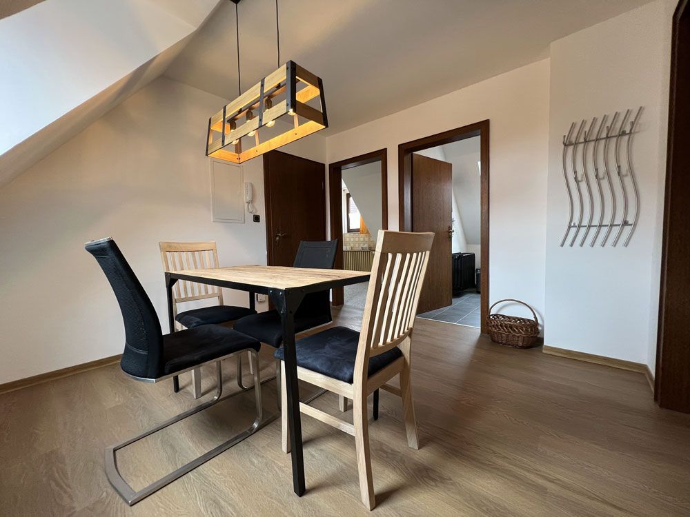 Ein Esszimmer mit einem Tisch und Stühlen in einem Haus.