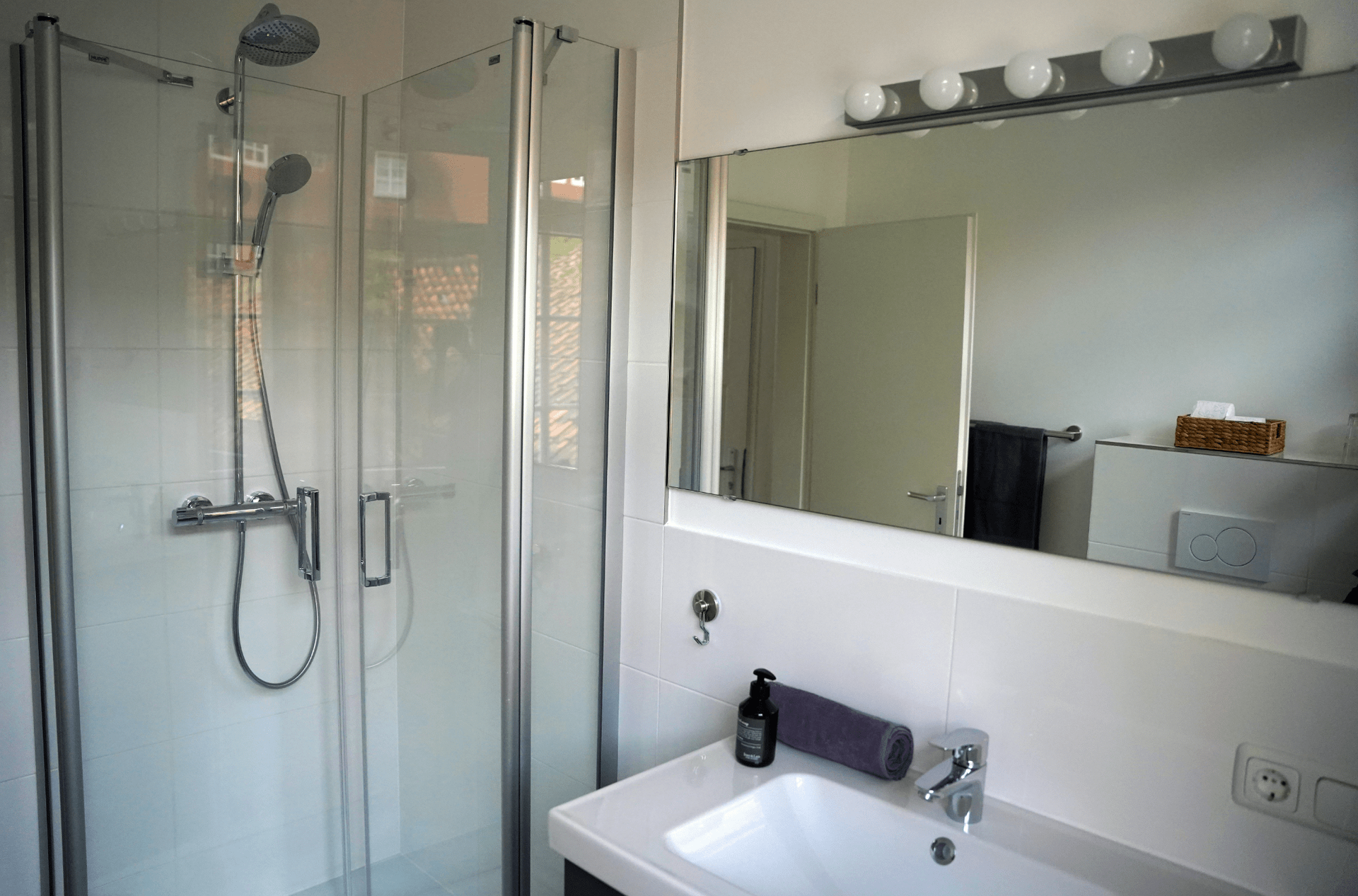 Ein Badezimmer mit Waschbecken, Dusche und Spiegel.