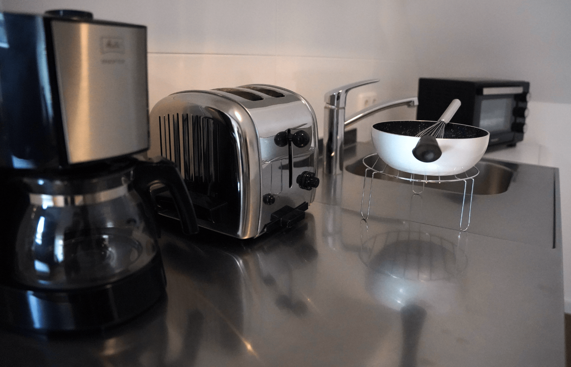 Eine Küchentheke mit Toaster, Kaffeemaschine und Schüssel