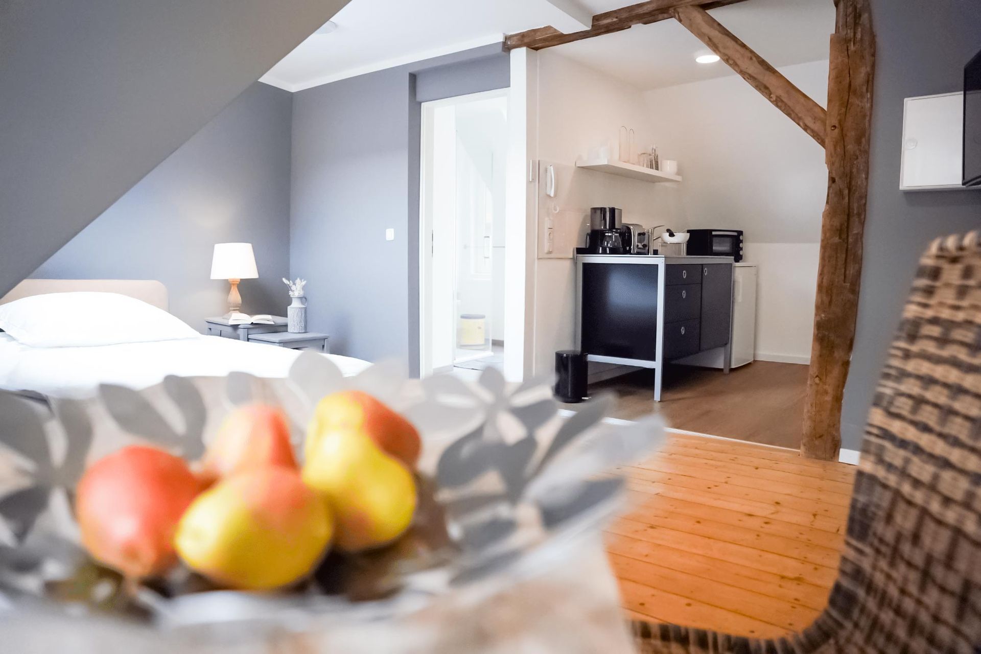 Eine Schale mit Obst steht in einem Wohnzimmer neben einem Bett.