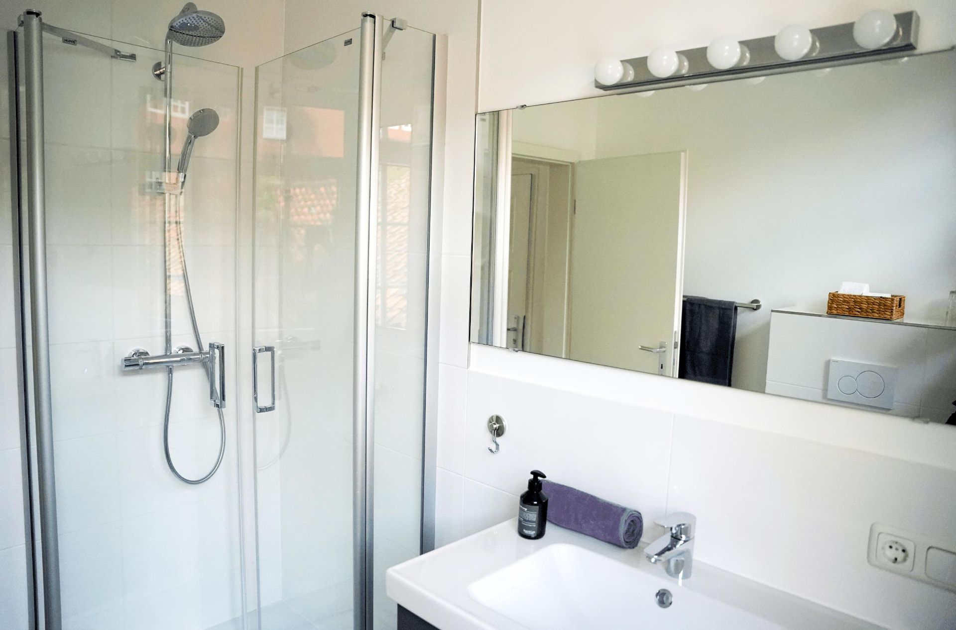 Ein Badezimmer mit Waschbecken, Dusche und Spiegel.