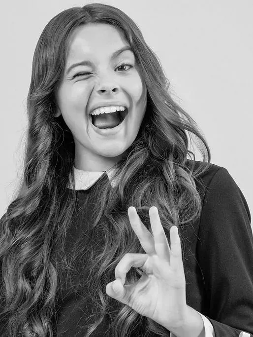 Una fotografía en blanco y negro de una niña haciendo el signo de ok.